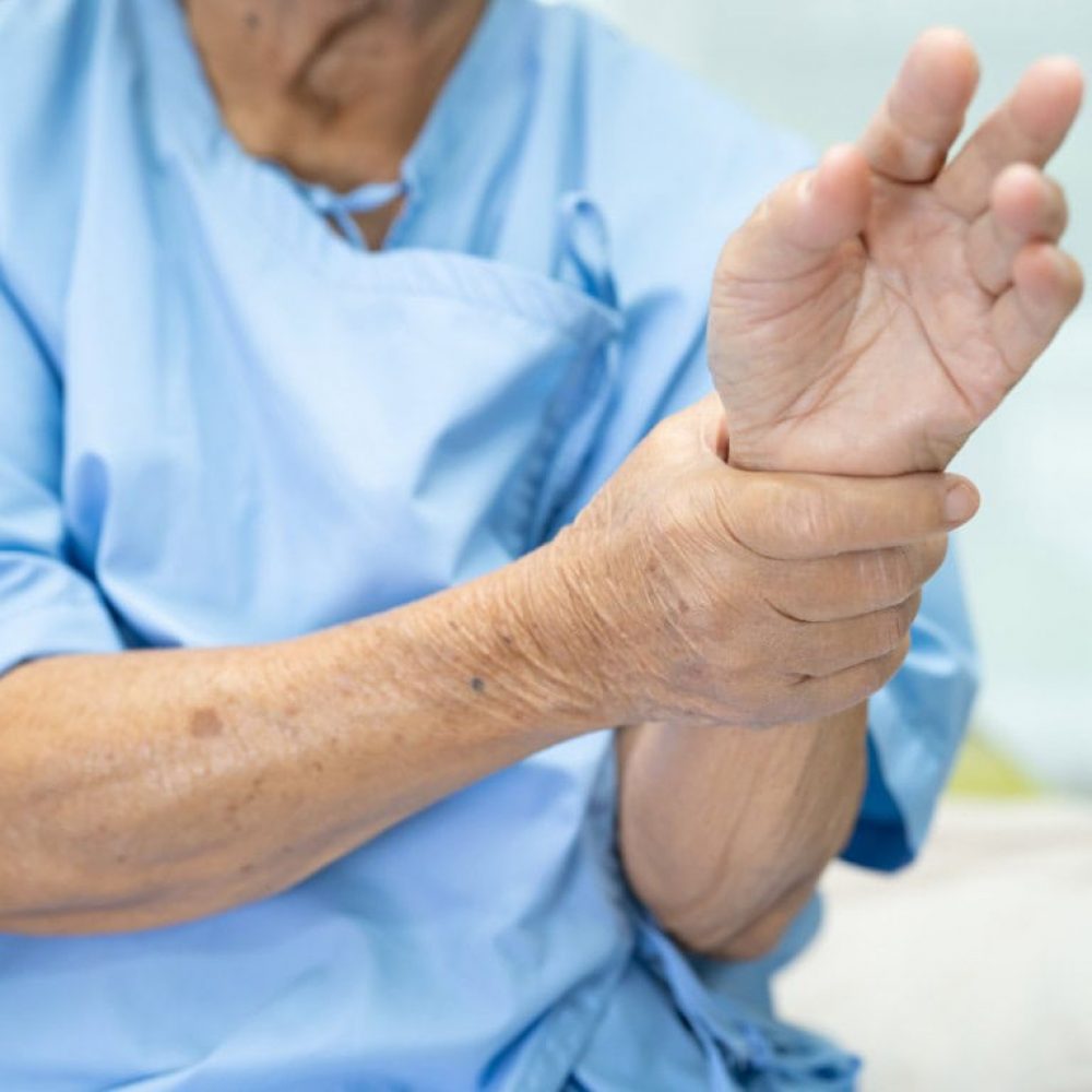 vieille dame en chemise d'hopital ayant mal au poignet